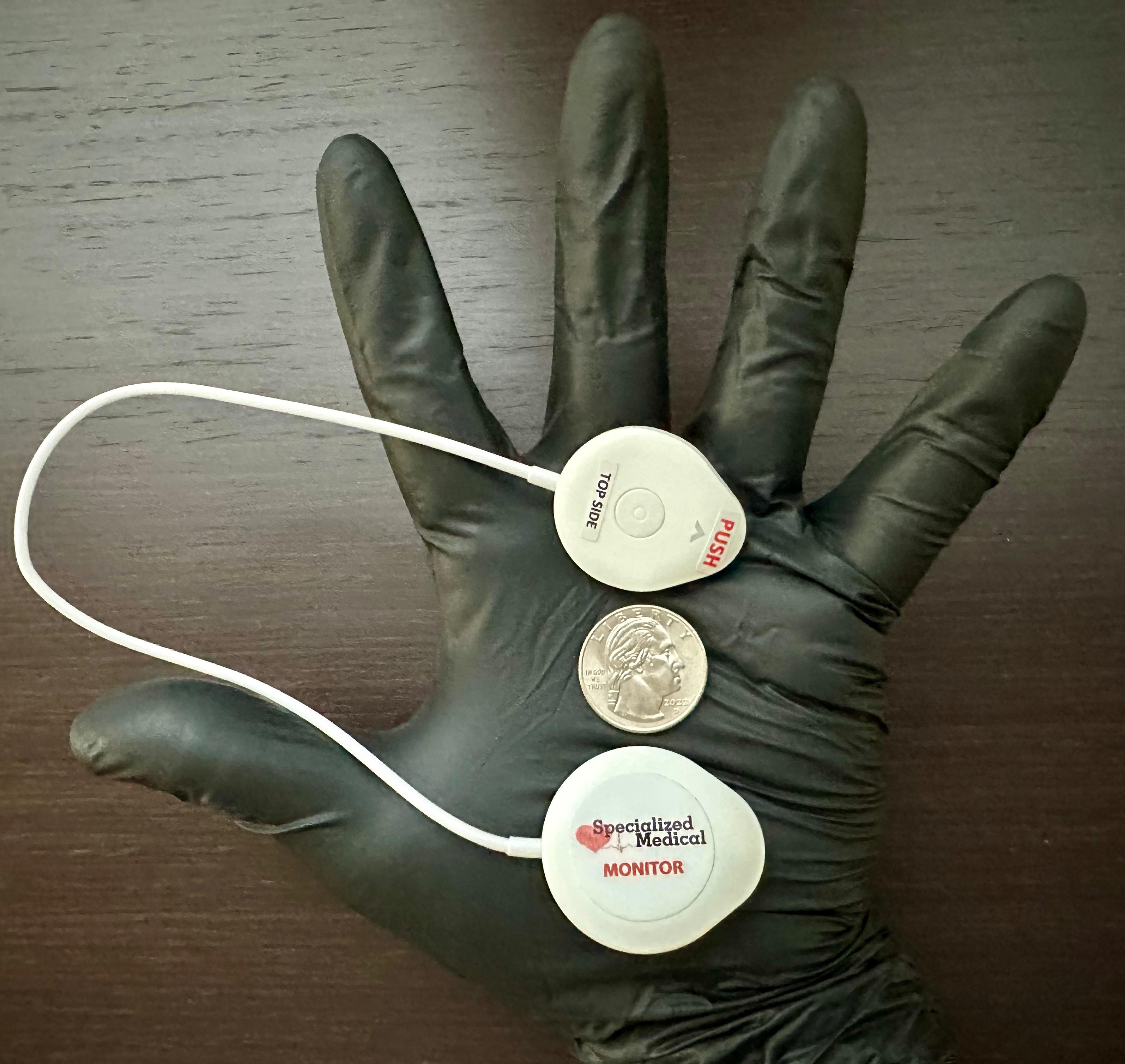Hand holding compact cardiac monitor